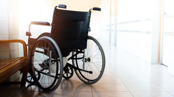 An empty wheelchair in the hallway of a nursing home.