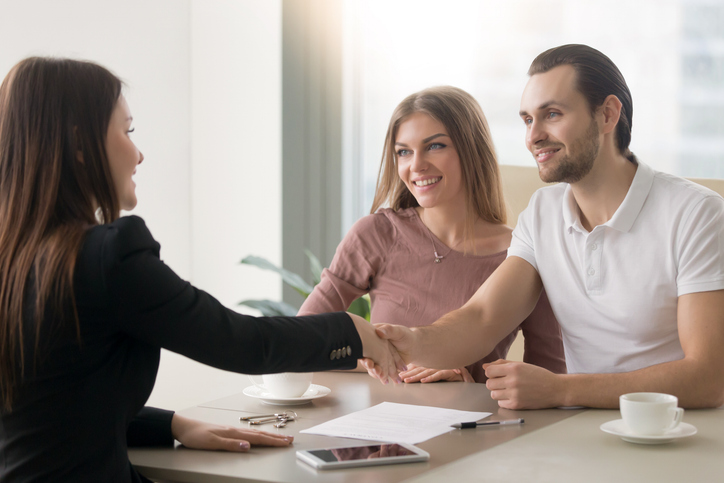 A couple meeting with a financial advisor to discuss a strategy to lower their net investment income tax (NIIT).